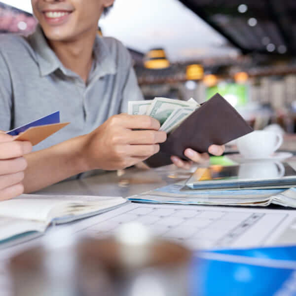 Une personne souriante tenant un portefeuille rempli d'argent liquide et de cartes de crédit, illustrant l'approbation rapide d'un prêt.