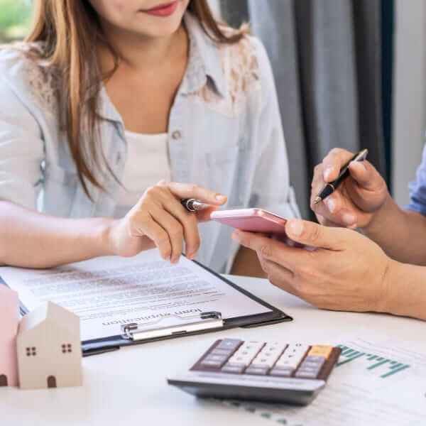 Un couple heureux dans leur salon regardant un ordinateur portable et tenant une carte de crédit, discutant de la croissance des prêts personnels en ligne.